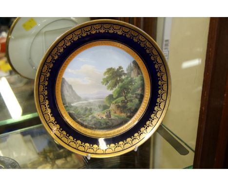 A 19th century Continental porcelain cabinet plate, the painted landscape scene titled 'Vue du Rhone dans le bas Valais', 22c