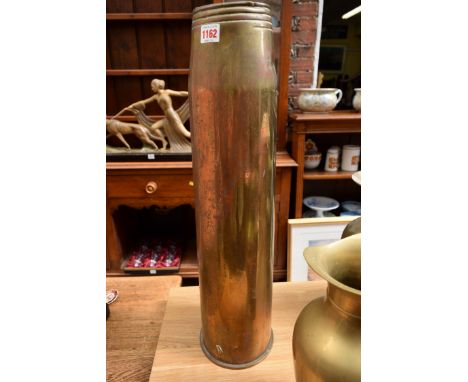 A large brass shell stamped with broad arrow and 1966, 64cm high; together with a pair of large brass ewers.