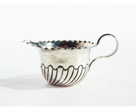 An Edwardian silver sugar bowl with cut card borders, raised on pad feet, Birmingham 1902 together with a silver cream jug, S