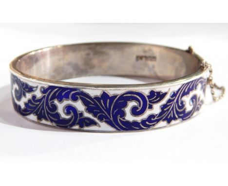 A sterling silver and enamel bangle with foliate scroll blue and white enamelling 