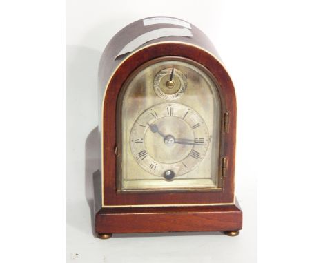 Early 20th century ivory inlaid mahogany mantel clock, the arched case with silvered dial, having fast/slow dial and movement