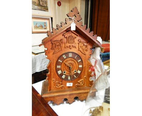 Carved oak cuckoo-style wall hanging clock with carved pierced pediment, foliate scroll decoration, central opening aperture 