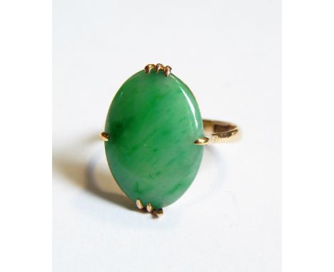 A gold and jade ring, the oval jade in a four-claw setting, marked 18K and with character marks 