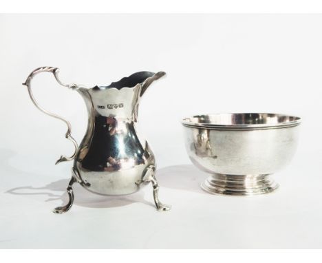 A silver cream jug with 'S' scroll handle, scroll shaped tripod supports with pad feet, Chester 1921 and a plain silver sugar