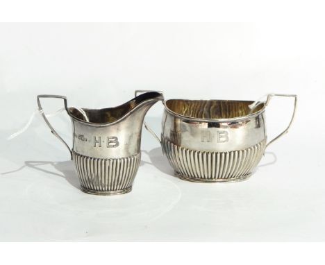 A late Victorian silver cream jug of half-reeded form, Sheffield 1901 and a matching oval sugar basin with two handles, Sheff