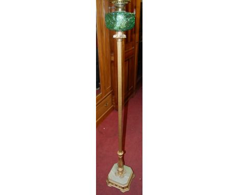 An early 20th century gilt metal and onyx freestanding oil lamp, having moulded green glass bowl, h.160cm 