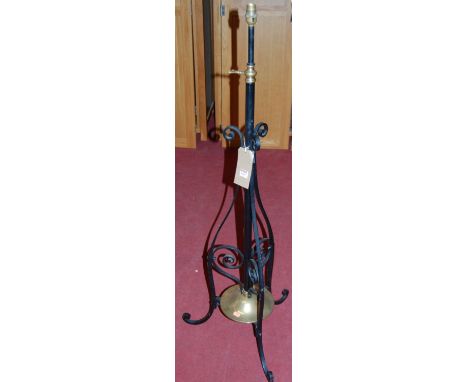 An early 20th century black painted wrought iron and brass telescopic standard lamp; together with a brass fire kerb and an o