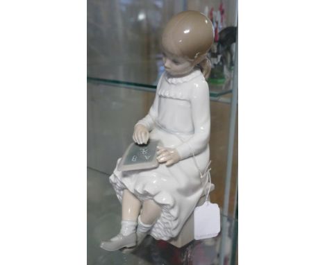 Nao style Spanish porcelain figure of a girl seated 