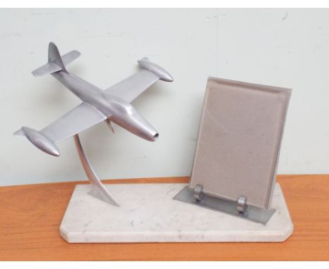 Photo frame decorated with model airplanes standing on white marble plinth 