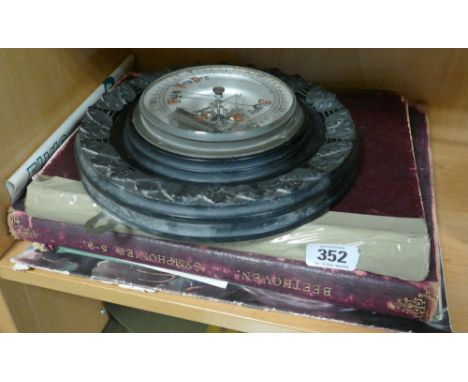 Shelf of books, old music and wall mounting barometer 