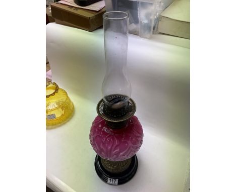 Victorian oil lamp with pink China reservoir and yellow glass shade on a brass and black base.