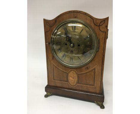 A Regency mahogany inlaid bracket clock with a brass dial and inlaid boxwood and shell motif with brass fittings. The mechani