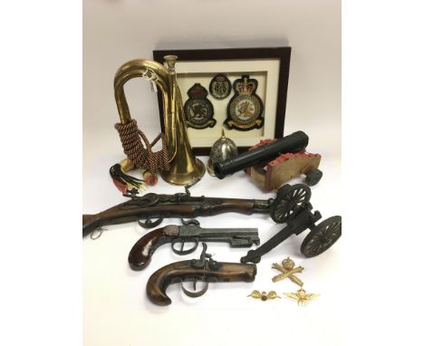 A collection of military related items comprising a bugle, RAF badges, model cannon etc.