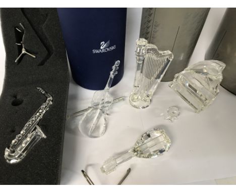 Five boxed Swarovski pieces including Violin, Saxophone, Grand Piano and Stool, Harp and Lute plus stand