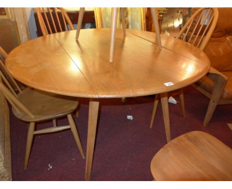 A 1960s Ercol light elm dining table with twin flaps raised on tapering supports