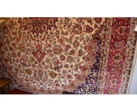 A Keshan style carpet the beige field having central medallion and floral motifs 