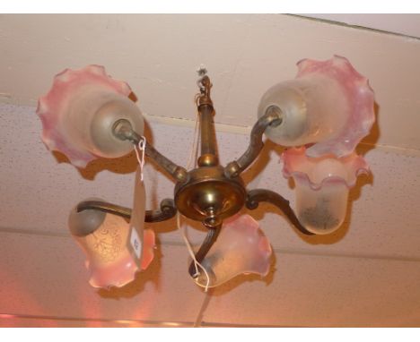 A vintage brass five branch chandelier having frosted glass shades