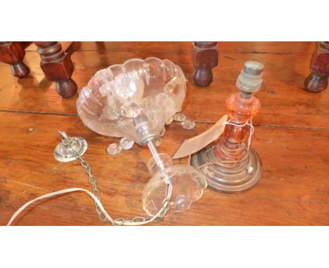 A crystal glass hanging light and an orange glass table lamp
