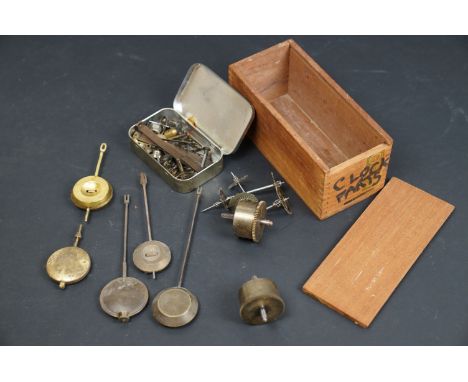 A collection of vintage clock parts contained within a wooden box. 