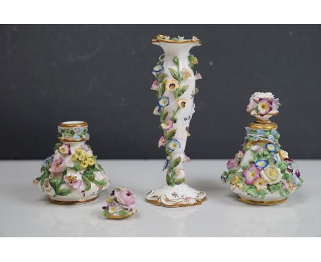 A pair of antique floral decorated Meissen lidded bottles together with a Meissen candlestick of similar pattern. 