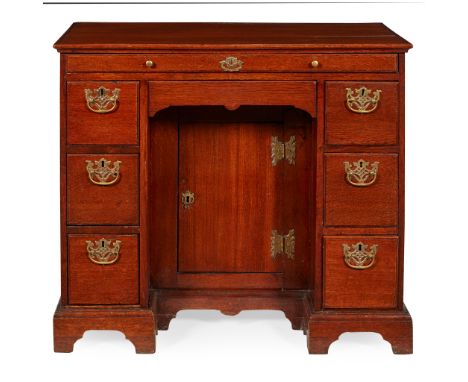 GEORGE II OAK KNEEHOLE DESK MID 18TH CENTURY the moulded top over a brushing slide and kneehole recess with arch drawer and c