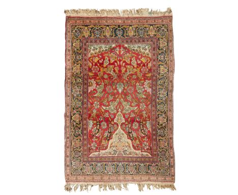 KIRMAN PRAYER RUG CENTRAL PERSIA, LATE 19TH/EARLY 20TH CENTURY the red field with allover foliate vine pattern and half medal