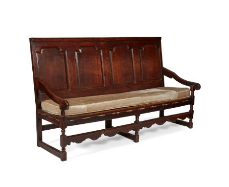 GEORGIAN FOUR PANEL OAK SETTLE 18TH CENTURY the back with four arch moulded panels above a rope strung seat with squab cushio