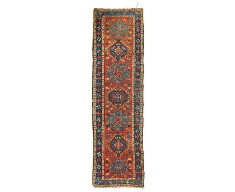 KARAJA RUNNER NORTHWEST PERSIA, LATE 19TH/EARLY 20TH CENTURY the red field with seven blue and indigo medallions, within indi