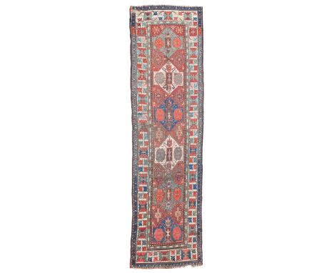 KAZAK RUNNER SOUTH CAUCASUS, LATE 19TH/EARLY 20TH CENTURY the rust red field with six polychrome medallions, within ivory har