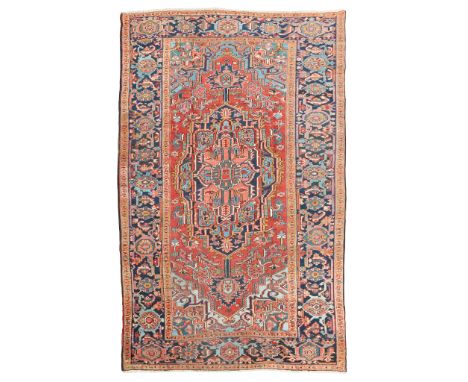 HERIZ CARPET NORTHWEST PERSIA, EARLY 20TH CENTURY the brick red field with elongated indigo and pink medallion suspending pen