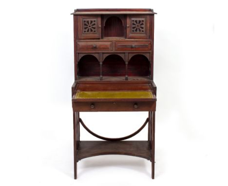 AN ARTS AND CRAFTS MAHOGANY WRITING DESK  probably by Maples, with pierced doors above two frieze drawers, a shaped superstru