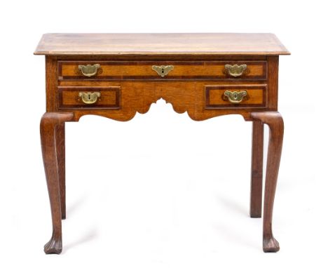 A GEORGE III OAK LOW BOY with one long and two short mahogany cross banded drawers, standing on cabriole legs terminating in 