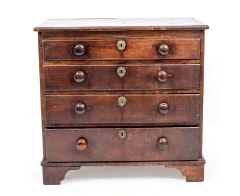 A GEORGE III MAHOGANY SMALL CHEST OF DRAWERS fitted with four graduated drawers with turned handles, standing on bracket feet