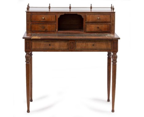 AN EDWARDIAN WALNUT WRITING DESK with a galleried top, four fitted drawers, pigeon hole and a green leather inset top over tw