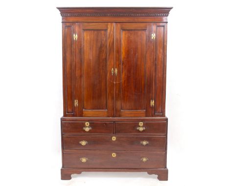 A 19TH CENTURY MAHOGANY LINEN PRESS with twin panelled doors above two short and two long drawers with brass handles and brac