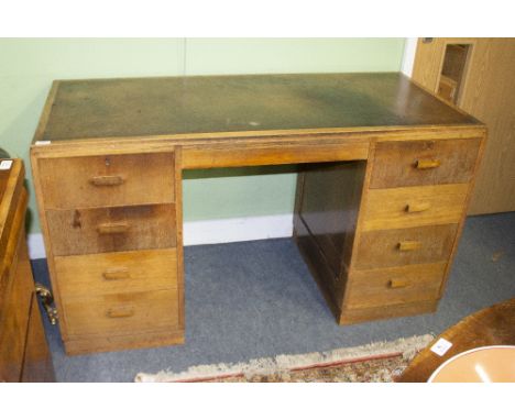 A HEAL'S KNEEHOLE LIGHT OAK DESK with a brown leather inset top above two pillars of four drawers, standing on a plinth base,