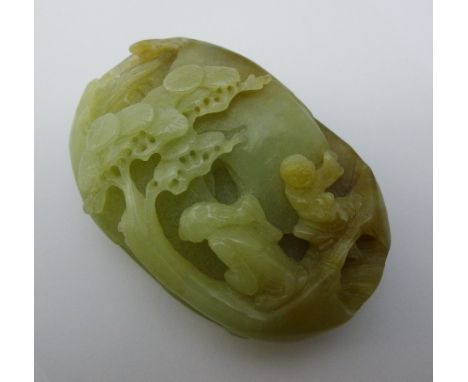 A Chinese carved green and russet jade pebble, worked with figures in a landscape