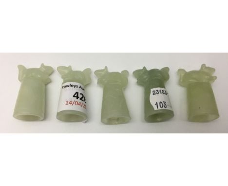 A set of five jade thimbles each surmounted with an animal