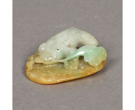 A Chinese carved green and russet jade group Worked as a toad on a lily pad.  5 cm long. 