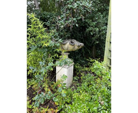 A COMPOSITION STONE GARDEN SCALLOP SHELL PLANTER ON STANDLATE 20TH CENTURYthe shell top supported on a fluted socle and a squ