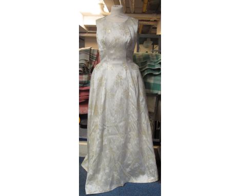 Vintage 1960's long sleeveless wedding dress made out of cream satin with gold roses decorating it and net underskirts. (B.P.