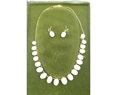 AN OPAL NECKLACE having nineteen oval graduated polished opalescent stones, white with flecks of colour, (possibly Australian