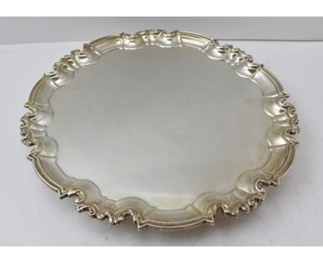 WILLIAM HUTTON &amp; SONS A CHIPPENDALE STYLE SILVER SALVER having cast and applied half round pie-crust wire rim, raised on 