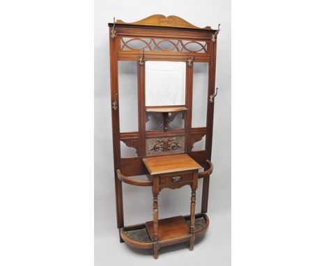 AN EDWARDIAN MAHOGANY HALL STAND, having mirror inset back with hanging hooks, central glove drawer flanked by stick/umbrella