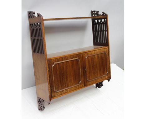 AN EDWARDIAN MAHOGANY WALL SHELF AND CUPBOARD UNIT, having Gothic tracery pierced sides, fitted two doors to cupboard, 61cm w