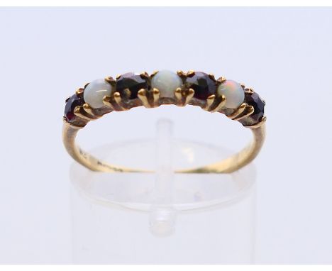 A 9 ct gold opal and garnet ring.  Ring size O/P.