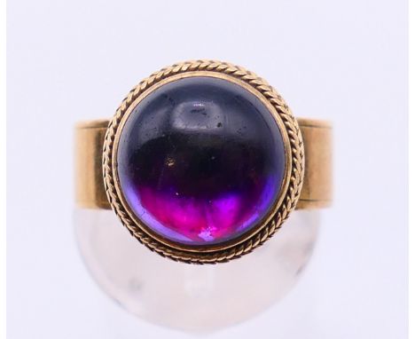 An unmarked gold cabochon amethyst ring.  Ring size K/L.
