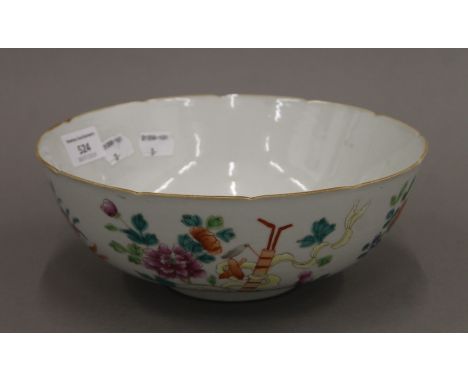 An early 20th century Chinese porcelain lobed bowl brightly painted with flowers and precious objects, seal mark to base, pap