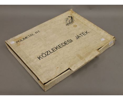 A boxed Polimetal (Hungary) tin plate toy car track with two cars, a bus and signs. The box 51 cm wide.
