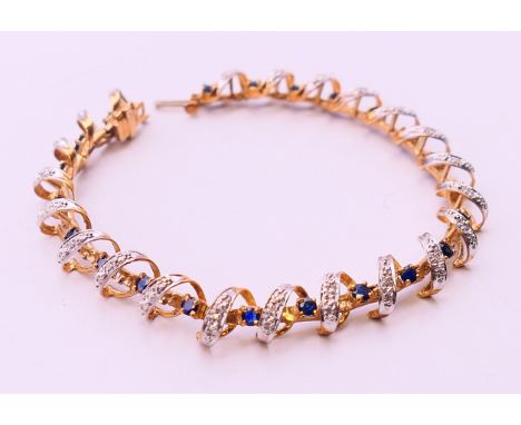 A 10 K gold, diamond and sapphire bracelet 10.7 grammes.  18 cm long.  